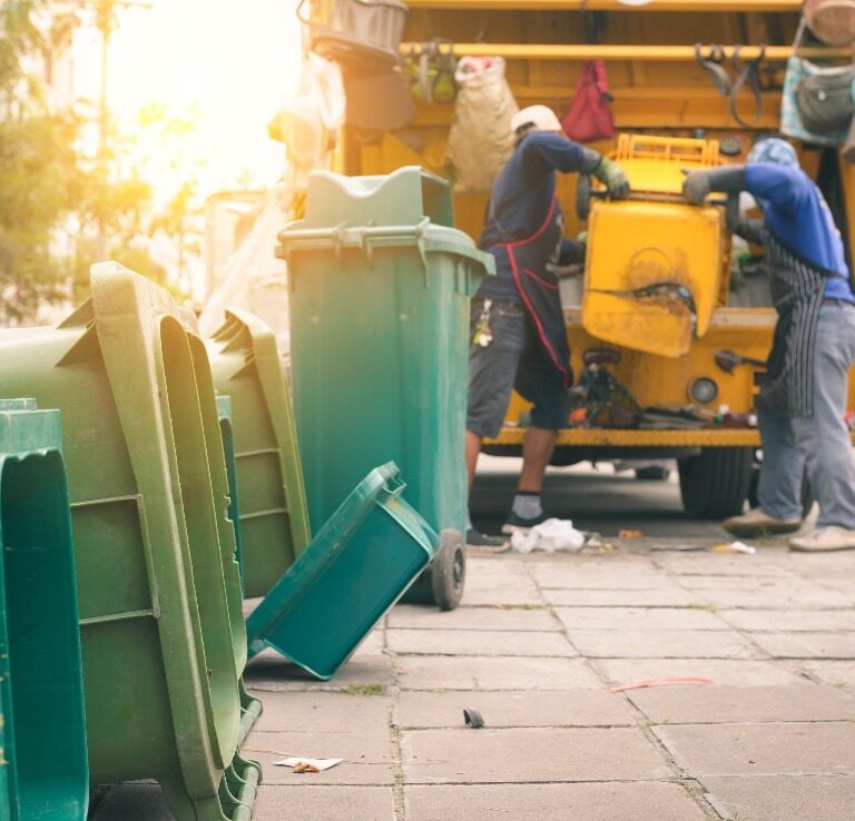 worker are loading waste into the garbage truck