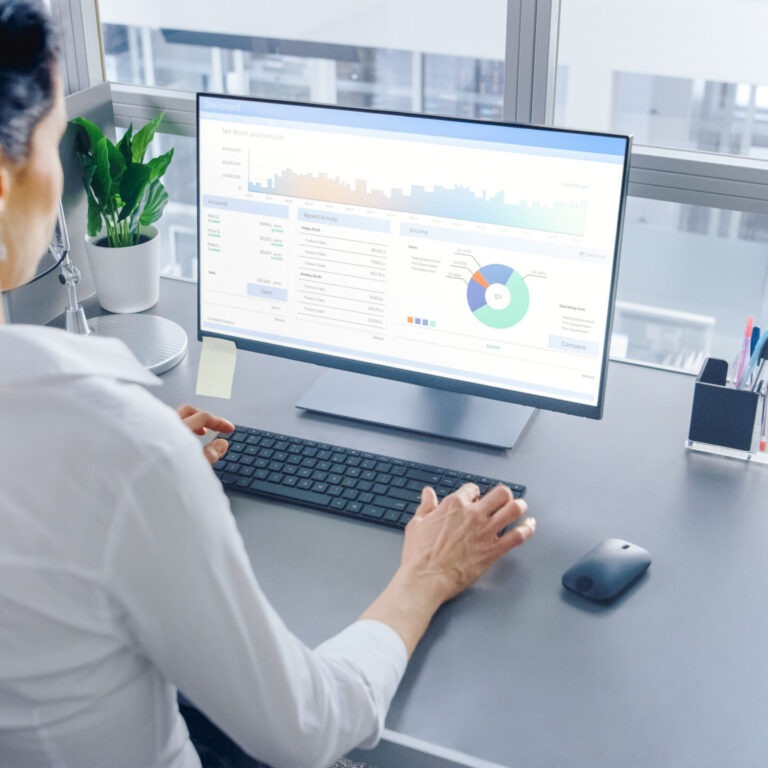 Businesswoman Working on Her Personal computer with Financial Data, Graphs and Statistics. Shot in Big Bright Modern Open Space Office